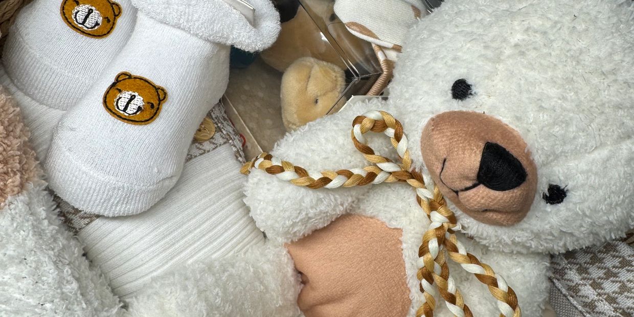 A cozy collection of baby items featuring bear-themed socks and a plush bear toy.