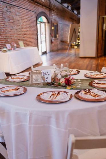 Rose gold charger plates, sage green table runner, disposable cutlery, DIY centerpiece