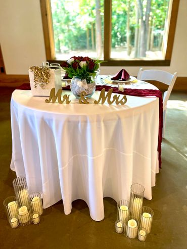 Sweetheart table floor candles burgundy winery wedding 