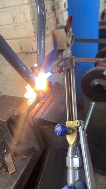 A blowtorch welding metal pieces in a workshop.