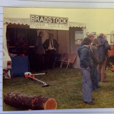 Vintage outdoor booth for Bradstock Power Tools with people gathered around.