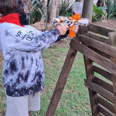 Child playing with a toy gun outdoors.