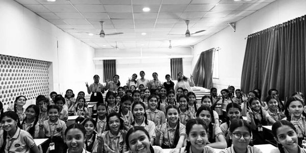 A large group of smiling students in a classroom, posing for a photo.