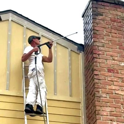 crew member of Anaya pro painting pressure washing exterior in kingwood Texas prepping to repaint 