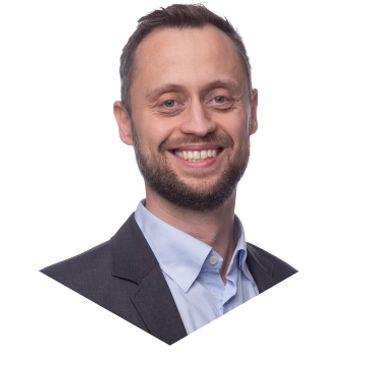 Smiling man in business attire against a white background.