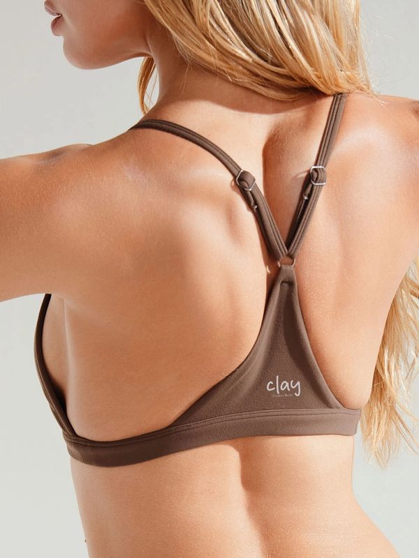 Back view of a woman wearing a brown Clay swim top with adjustable straps.