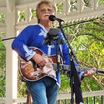 Gary David Reece playing his Taylor T5z Custom 12 String at an outside venue .
