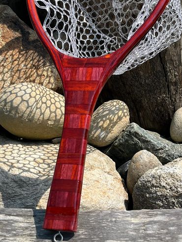 Close-up of wooden fishing net handle and mesh.