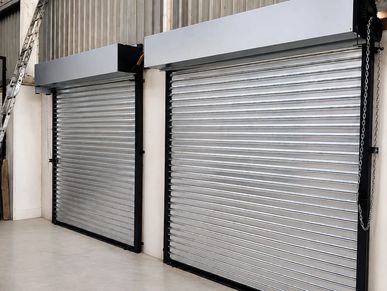 Two closed metal roller shutters inside a building.