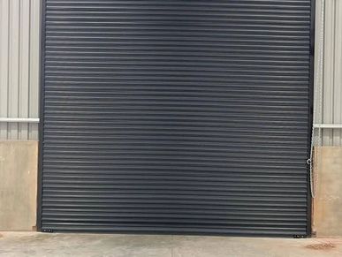 Closed black industrial rolling shutter door.