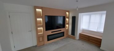 Media wall with LED lit alcoves, TV, fireplace and shaker doors
