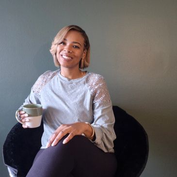 Woman smiling while holding a cup.