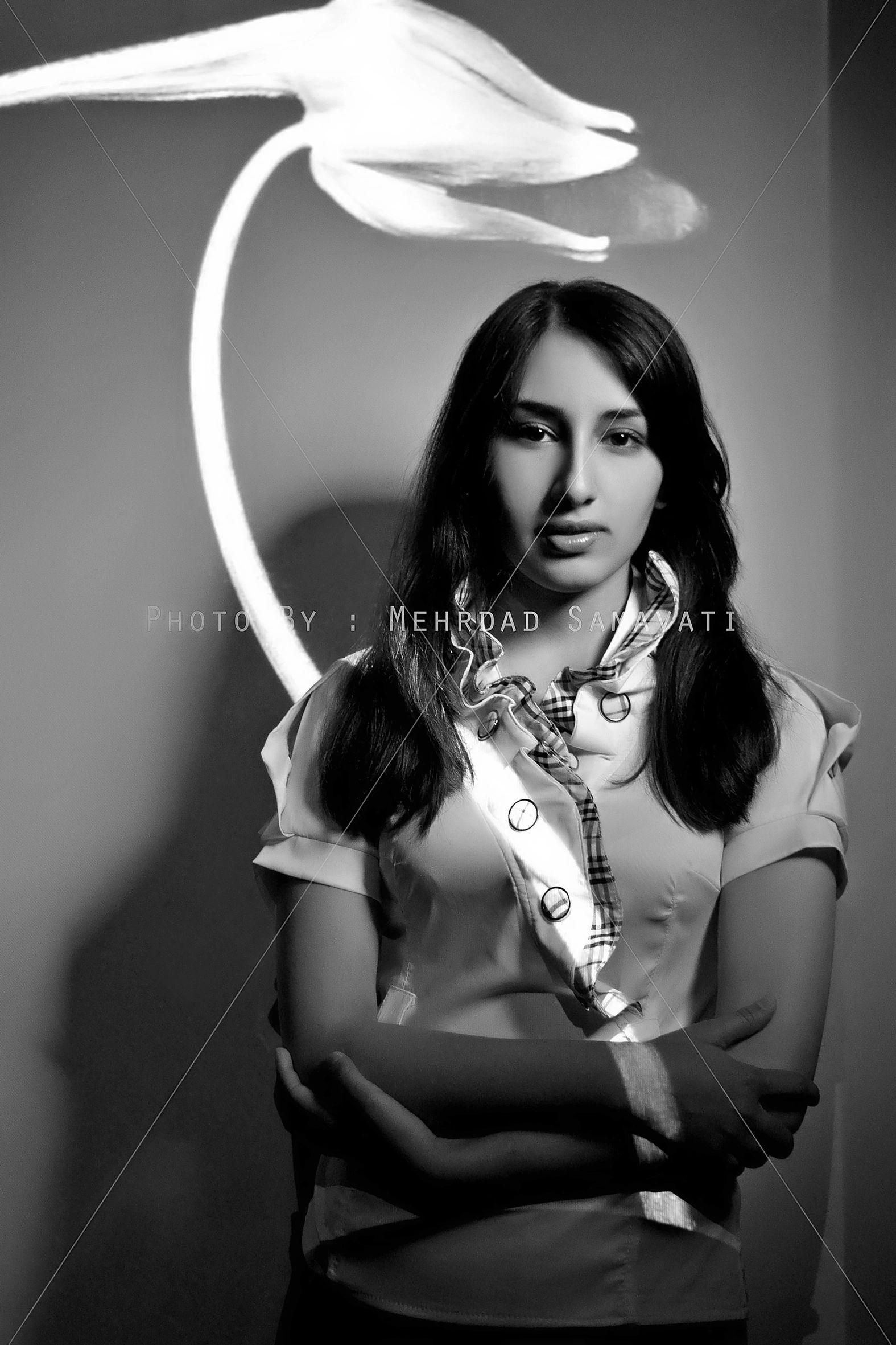 Black and white portrait of a woman with a flower projected behind her. 