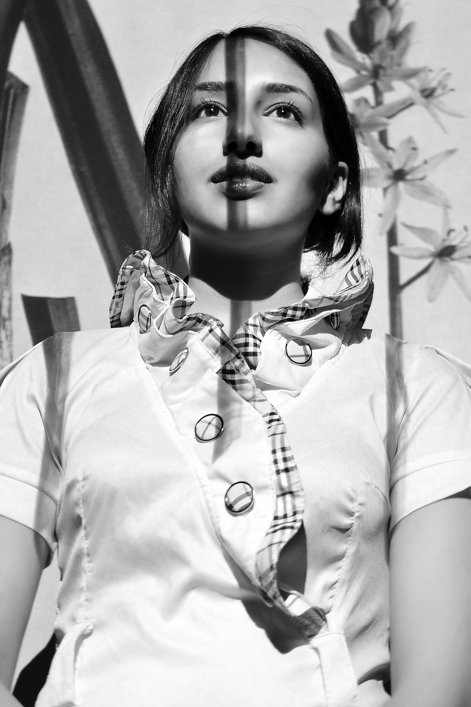Black and white portrait of a woman with shadows across her face.Fine art portrait photography using