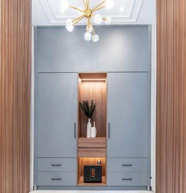Modern built-in wardrobe with blue-grey doors and wooden accents.