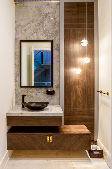 Modern bathroom vanity with marble countertop and wooden cabinetry.