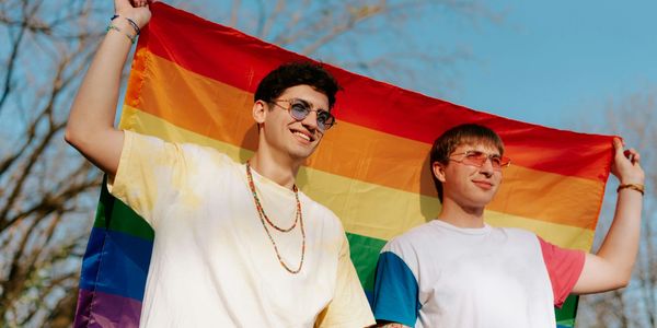 two men holding up a pride flag