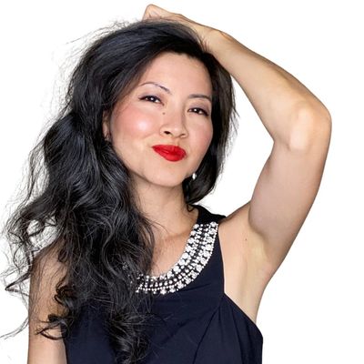 Woman with long black hair and red lipstick posing confidently.