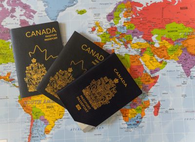 Three Canadian passports on a world map.