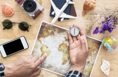 Traveler planning a trip with map and compass.