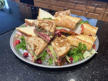 A platter of assorted sandwiches with fresh lettuce and garnishes.