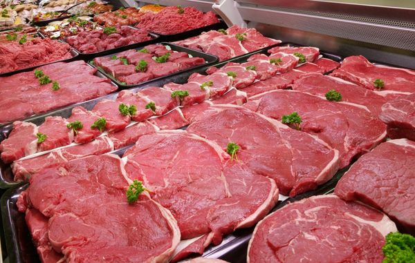 A selection of raw beef in a refrigerated counter.