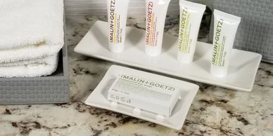 Hotel toiletries displayed on a marble countertop.