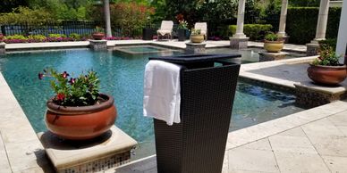 Poolside towel holder near a hot tub seating area.