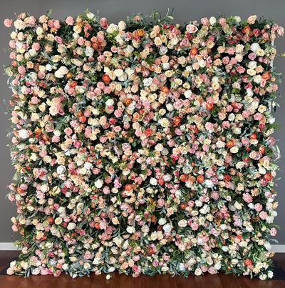 A dense floral wall covered in various pastel-colored roses.