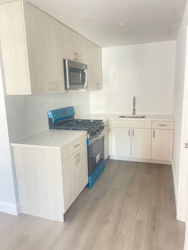 Modern kitchen with light wood cabinets and new appliances.