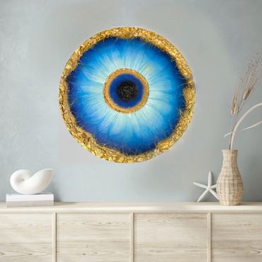 Blue and gold circular wall art resembling an eye above a wooden cabinet.