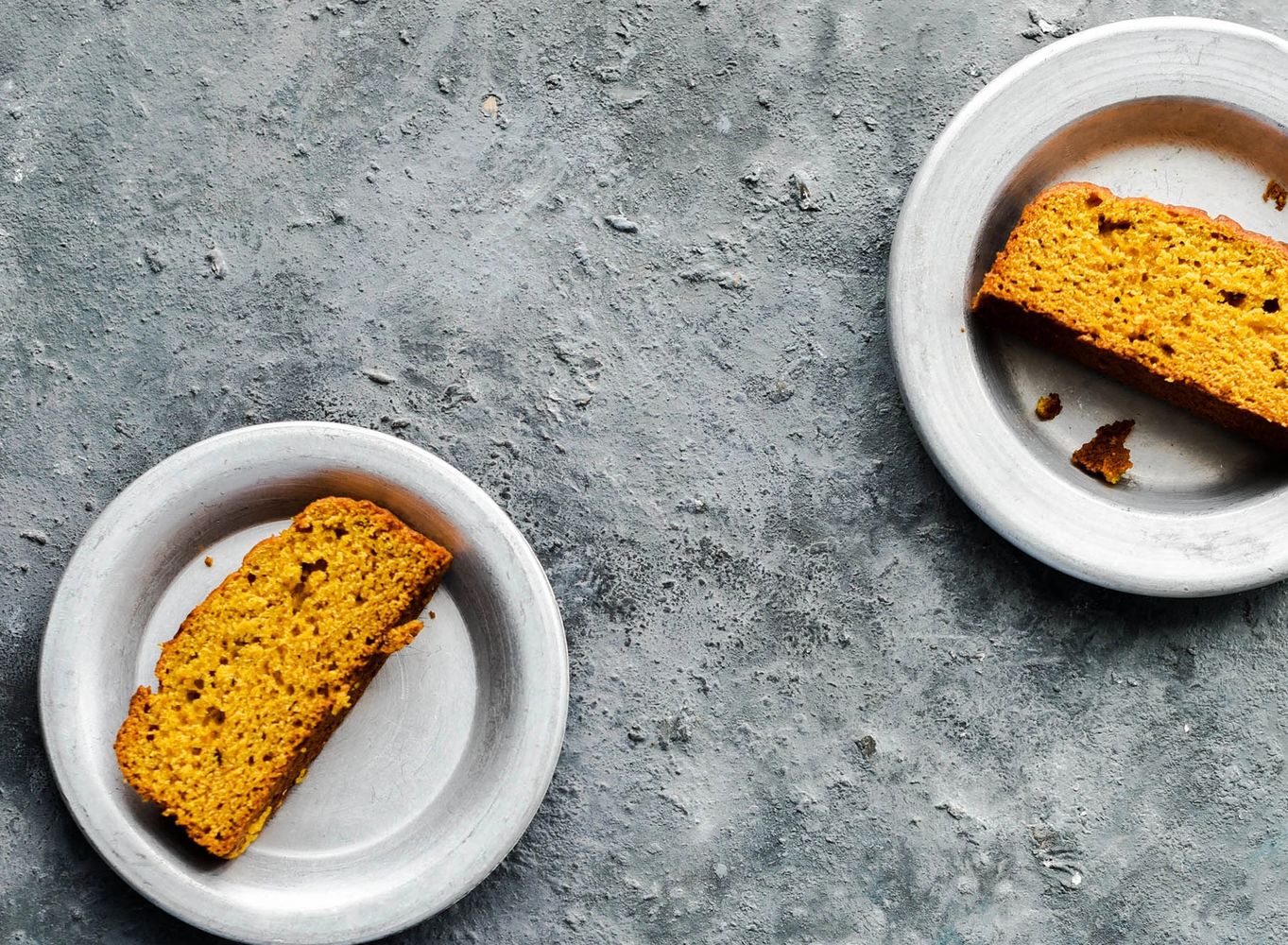 Overhead photograph of slices of pumpkin bread on plates.