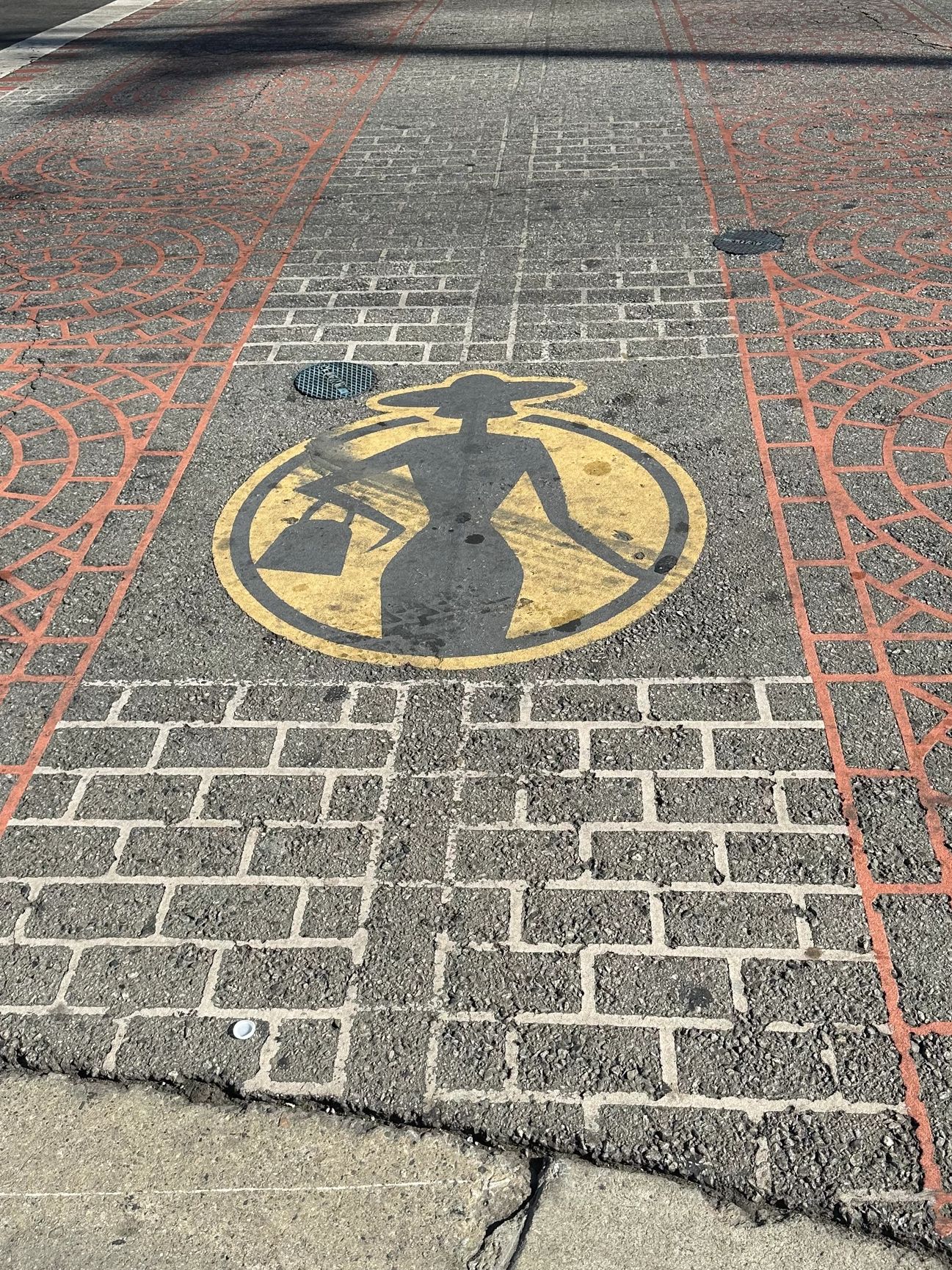 Street art of a fashionable woman with a handbag painted on the sidewalk.