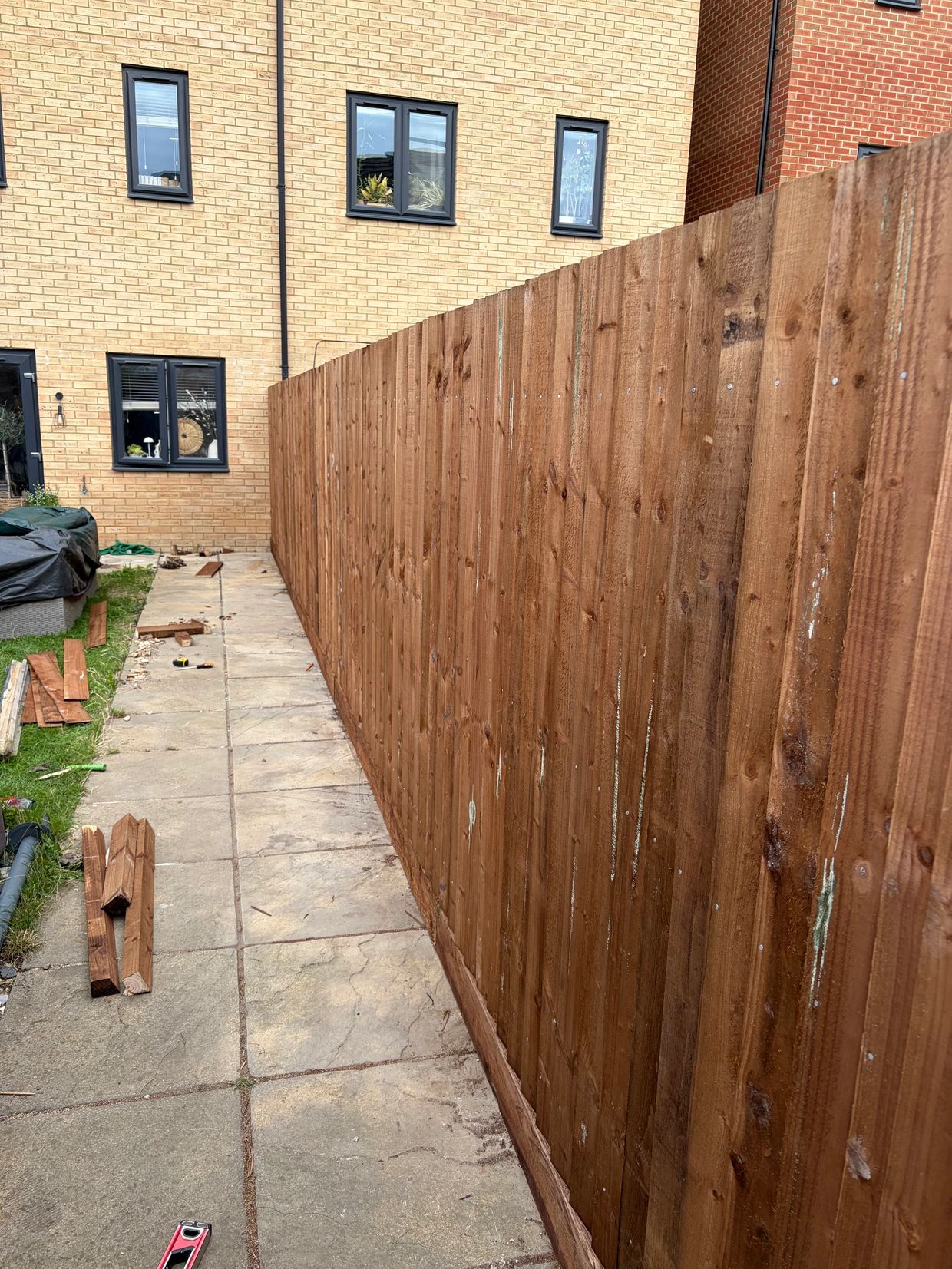 New wooden fence along a backyard walkway.
