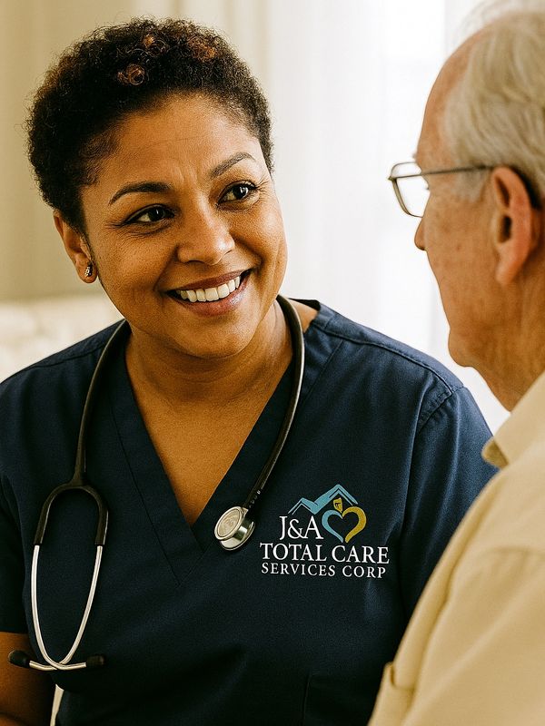 Smiling nurse with stethoscope talking to an elderly man.