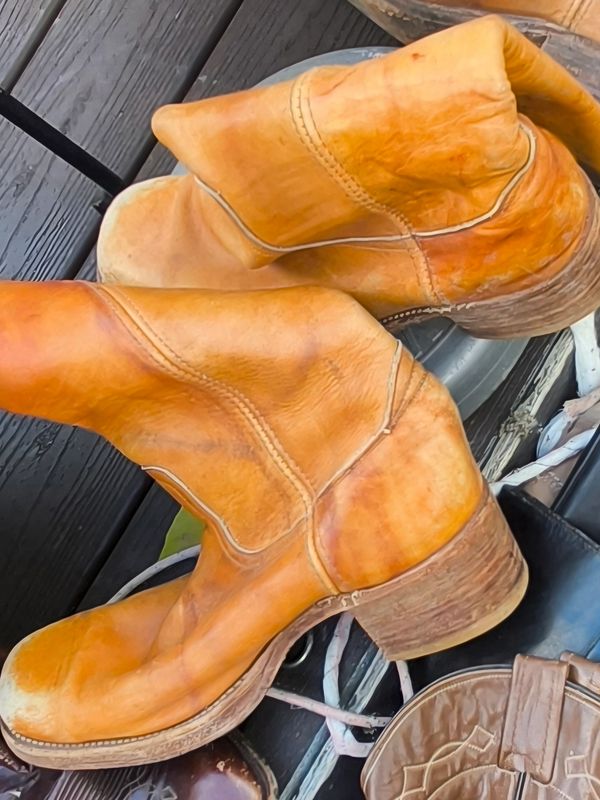 Worn tan leather boots with wooden heels.