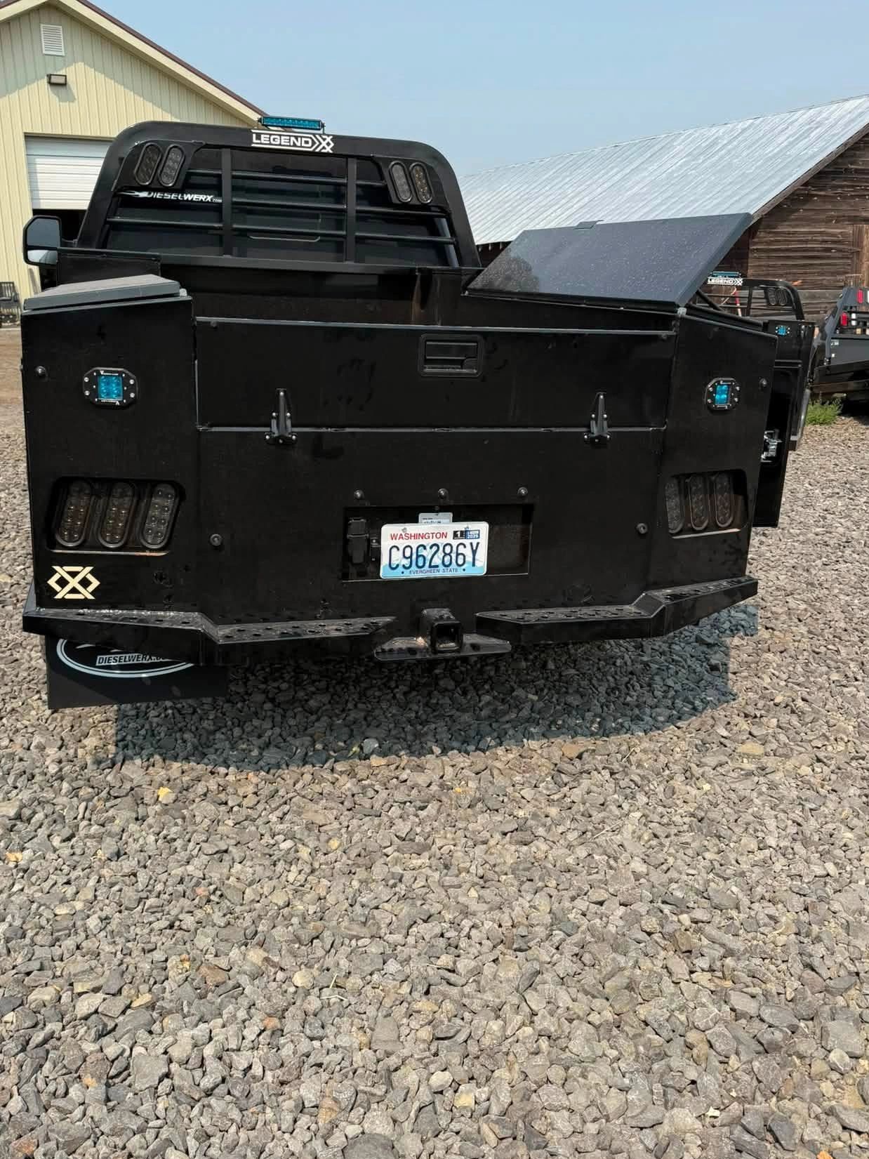 Black custom truck bed with storage compartments and Washington license plate.