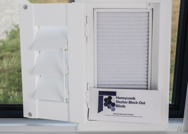 White honeycomb shutter block-out blinds on a window.