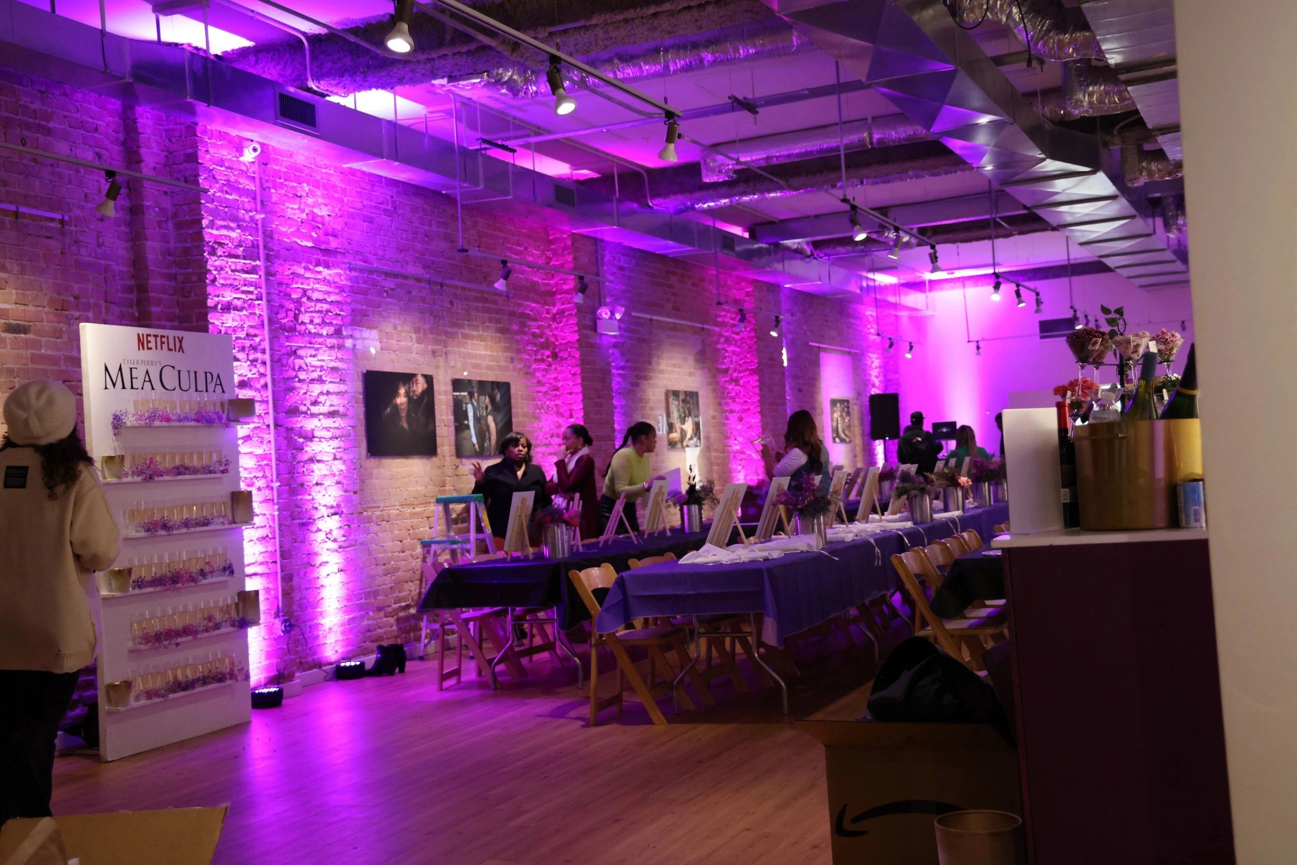 Event setup with purple lighting and Netflix Mea Culpa display.