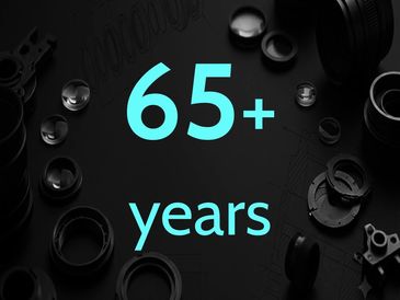 65+ years text with mechanical parts background.