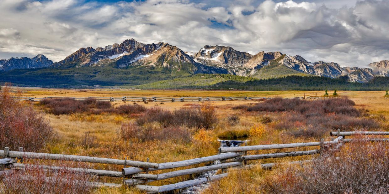 Mountain range with wooden fence and autumn landscape.