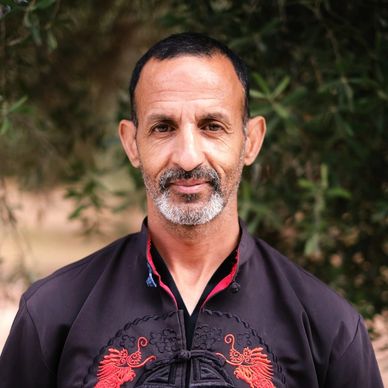 Portrait of a middle-aged man in a traditional embroidered jacket.