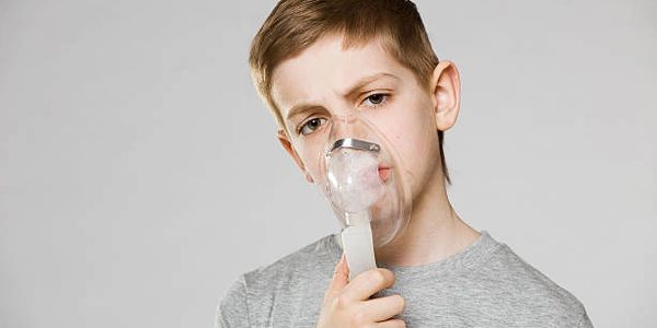 Child holding nebulizer nask