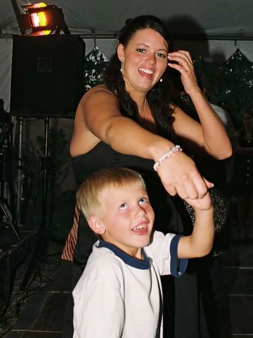 Woman and young boy dancing and smiling together joyfully.