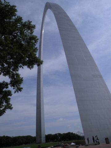 The Gateway Arch towering against a partly cloudy sky.