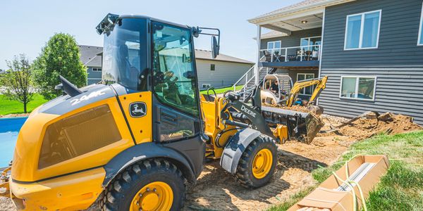 Loader working the backyard to clear dirt for a new retaining wall. 