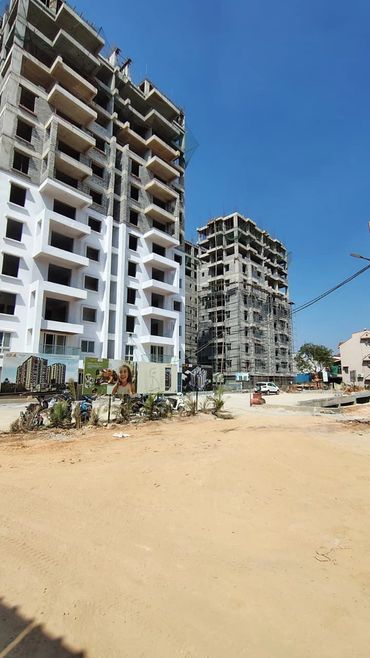 Two residential buildings under construction on a clear day.
