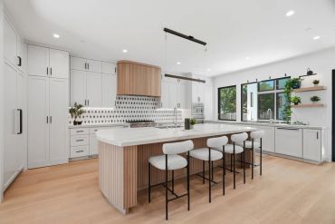 Modern kitchen with a large island and white cabinetry.