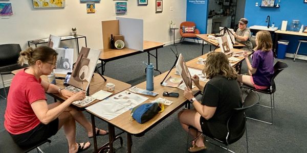 Group of women painting still life in an art class.