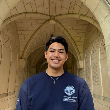 Young man smiling under an archway.